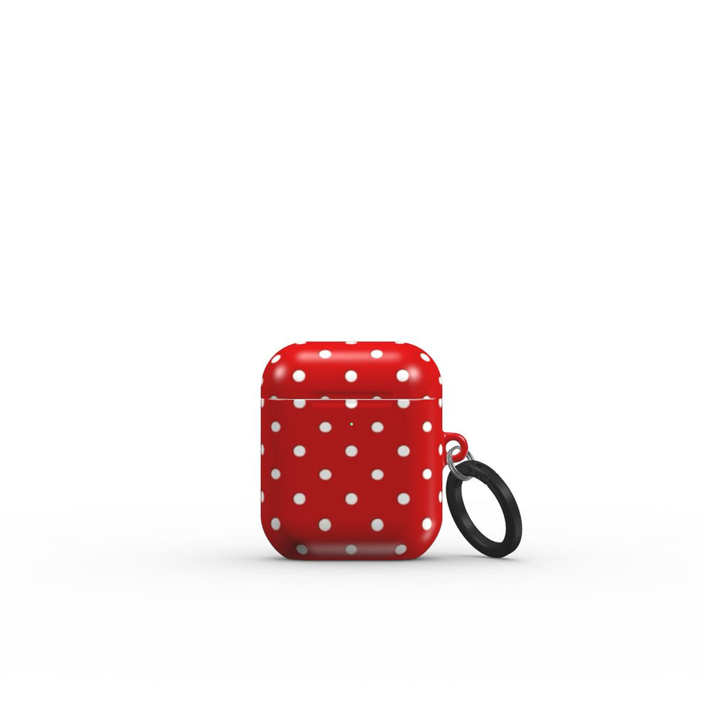 Red air pod case with white polka dots and a black strap on a white background