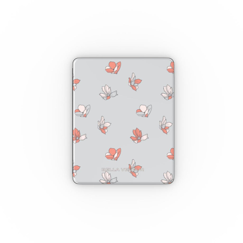 Apple iPad with a light pastel blue and peach floral patterned cover on a light gray background