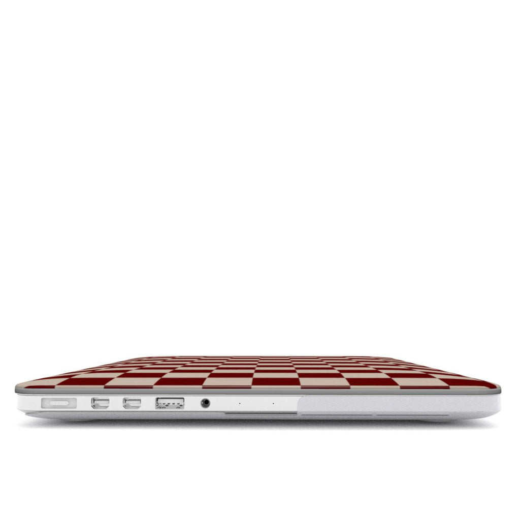 Laptop with a burgundy and white checkered design on a white background showing open ports from side.